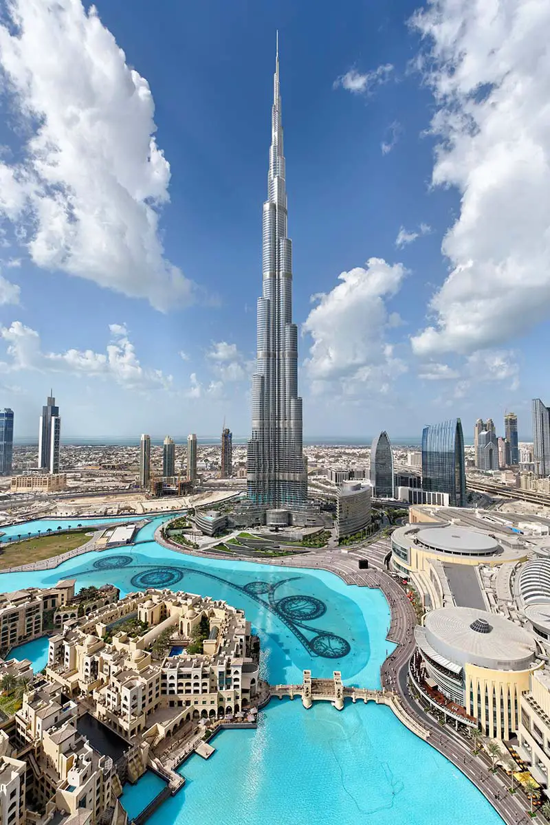 A tall curved building amongst a blue sky background in the city.