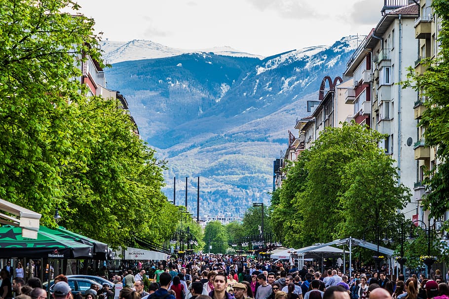 A picture of a crowded street with a mountain range in the background.