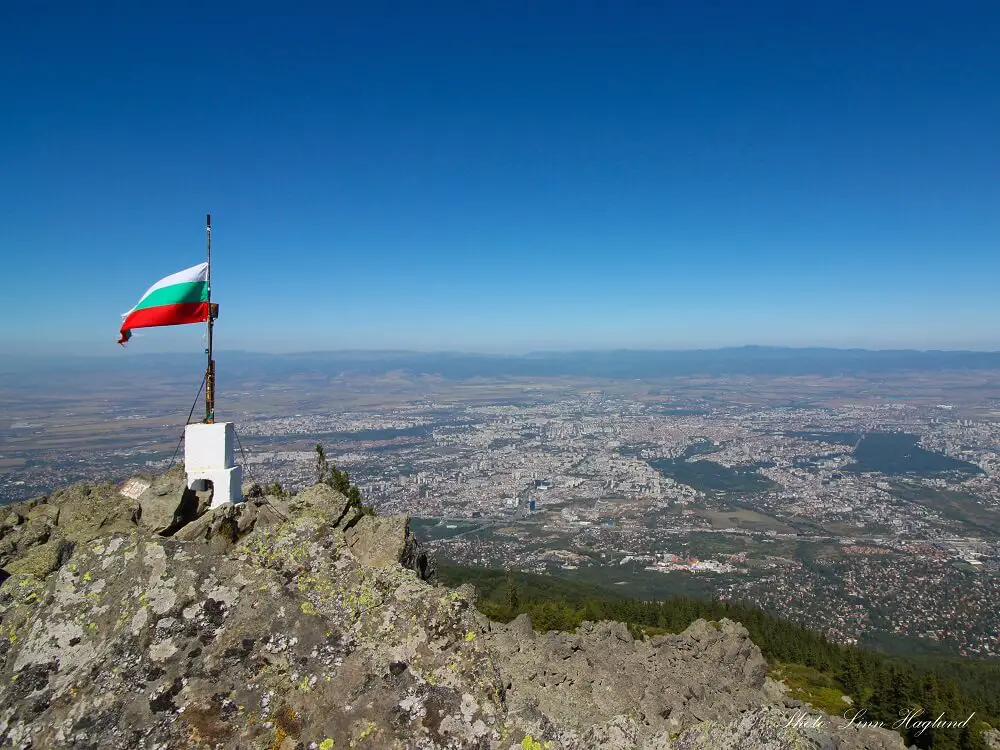 A view of a city from the peak of a mountain during daytime.